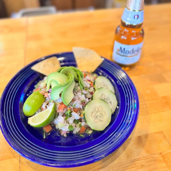 Taqueria La Flama's ceviche with avocado, lime, cucumber, and tortilla chips, alongside a Modelo beer.